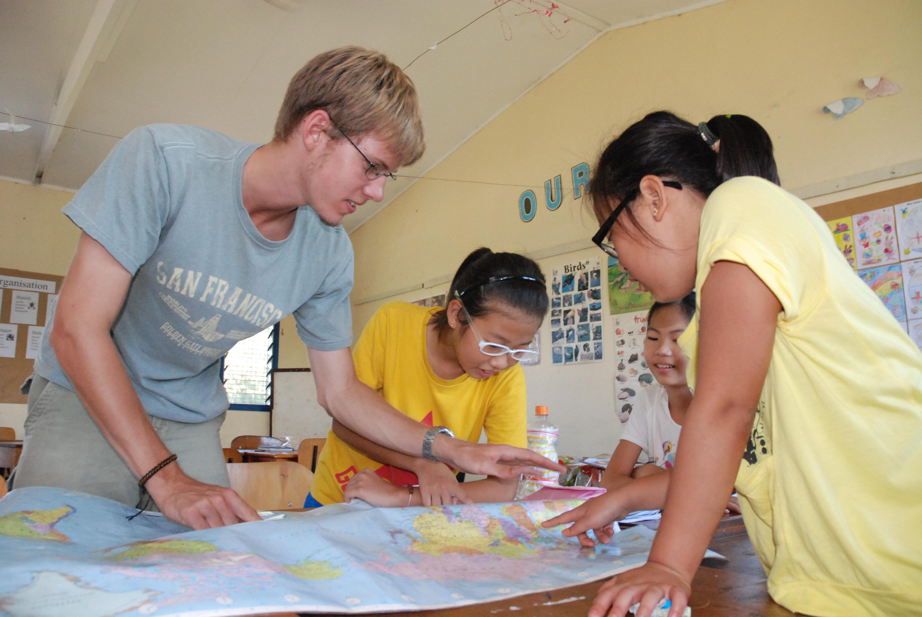 Projects Abroad volunteer gives a geography lesson to his students at one of our teaching placements in Fiji Students learn about basic geography from a volunteer teaching in Fiji